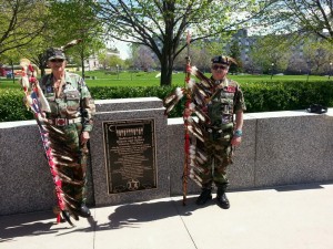 An honor guard of Native American veterans carrying eagle feather staffs stands next to a plaque honoring the state's "Dakota and Ojibwe Veteran warriors" that was dedicated Thursday at the Minnesota World War II Veterans Memorial